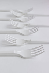 White plastic forks flat lay on white background