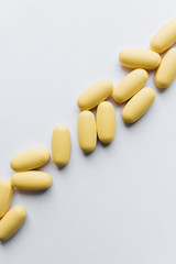 Scatterded yellow pills on white background 