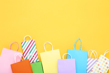 Small paper shopping bags on yellow background