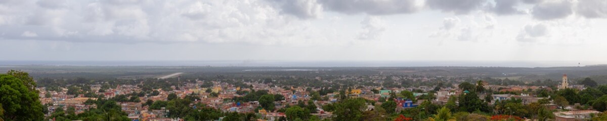 Aerial panoramic view of a small touristic Cuban Town during a colorful and cloudy sunset. Taken in Trinidad, Cuba.