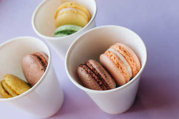 Composition of delicious macaroons on purple background