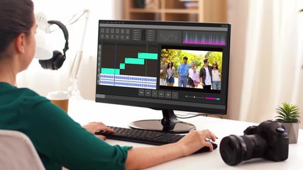 technology, post production and vlog concept - woman working in video editor program on computer at home office