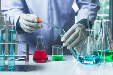 Researcher with glass laboratory chemical test tubes with liquid for analytical , medical,...