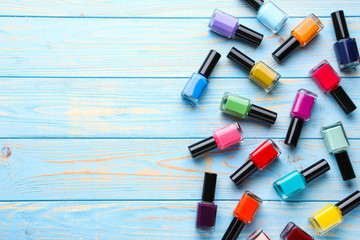 Nail polish bottles on blue wooden table