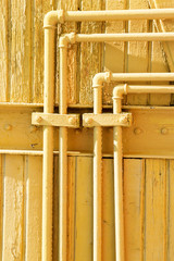 Old yellow pipes on the wooden wall. Scratch Grunge Urban country Background. Texture for your design.