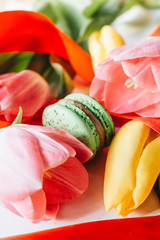 Delicious macaroon and bright tulips, sweet dessert 