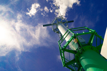 Port radar  in the harbor against blue cloudy sky and sun rays