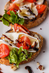 Bruschetta with tomatoes, lettuce, camambert, balsamic vinegar