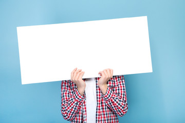 Young boy holding white blank board on blue background