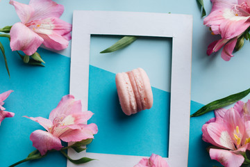 Piece of delicious macaroon on floral background with frame