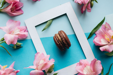Piece of delicious macaroon on floral background with frame