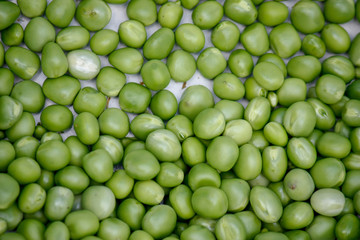 Background with fresh organic green peas. Close-up view from above.
