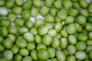 Background with fresh organic green peas. Close-up view from above.