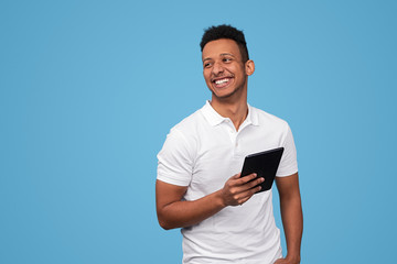 Laughing African male with tablet looking away