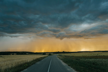 Fototapeta premium road to sunset and the oncoming thunderstorm