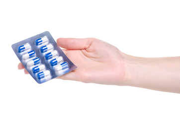 Pills capsules in blister in hand medicine health on white background isolation