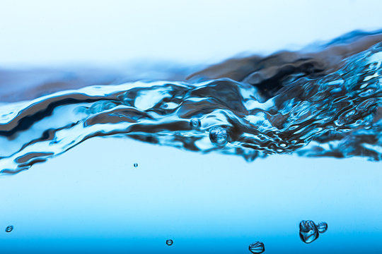 Water splash, clear blue water with waves and bubbless