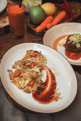 Healthy vegeterian food on brown wood board. Spring vitamin dieting food. Potato vegan pancakes with juice fruit and vegetables