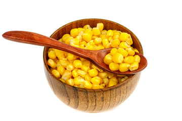 Corn seeds in a wooden spoon and cup (plate) isolated on white background