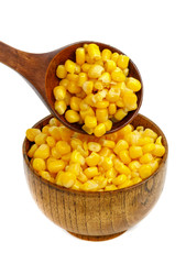 Corn seeds in a wooden spoon and cup (plate) isolated on white background