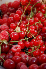 background of ripe juicy berries of red currants, raspberries and cherries. Close-up plan view from above.