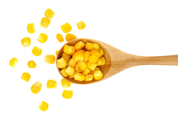 Corn seeds in a wooden spoon isolated on white background