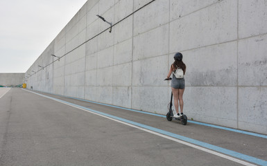 Teenage girl circulating with an electric scooter