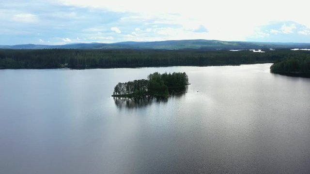The Drone Orbits around a Small Island, on a Fishing Lake in Norra Flät, Sweden. 4K Video in Day Time.
