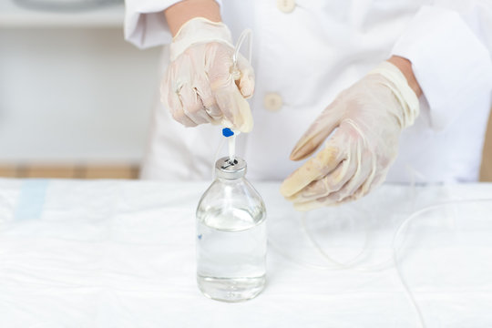 The doctor prepares a dropper with a solution of medicine. Close up.