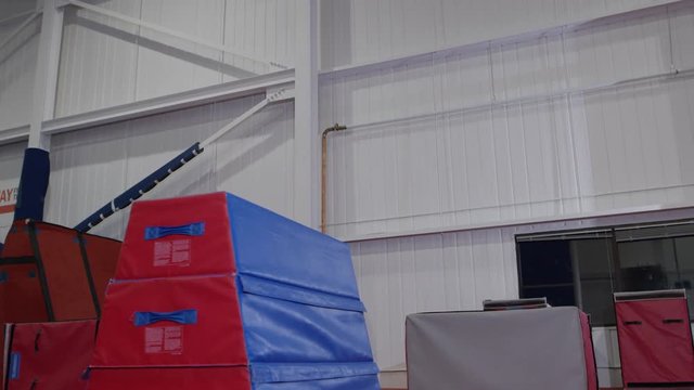 Man training in parcour in the gym with padded equipment and obstacles
