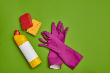 Detergents and cleaning accessories on a green background. Housekeeping concept.