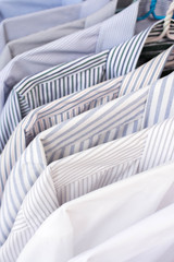 Men shirts hanging on rack in a row, Selective Focus