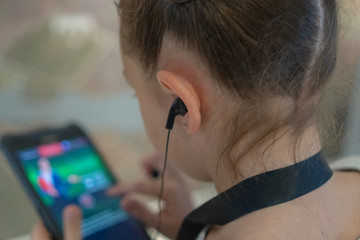 girl in museum listening to interesting information about exhibit through headphones