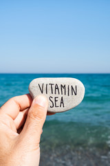 text vitamin sea in a stone on the beach
