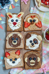 Obraz premium Funny animal faces toasts with spreads, banana, strawberry and blueberry