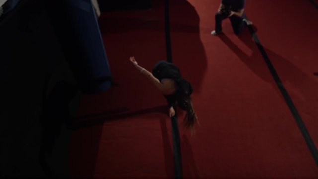 Female athlete doing impressive tumbling on trampolines and gym parcour equipment