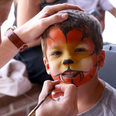 Little boy having his face painted