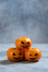 Funny orange mandarins or tangerines look like pumpkin jack o lantern