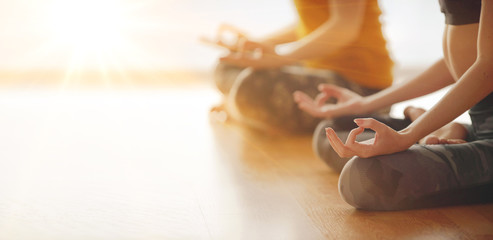 Two woman doing yoga flow in studio - obrazy, fototapety, plakaty