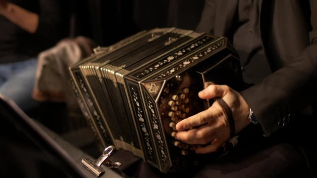 A Bandoneon accordion player is practicing for a tango music show.