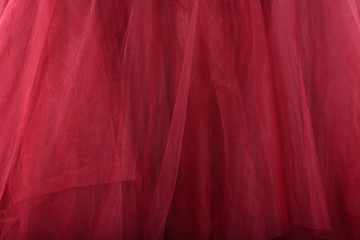 Red fabric texture background. The skirt is made of tulle