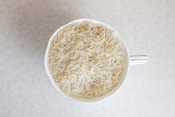 Heap of parboiled rice in glass bowl isolated on white background. Close up, high resolution product. Healthy food. Glass of white rice. Glass with white rice top view