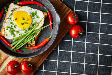 Scrambled eggs on the bread in the frying pan with vegetables - 277406280