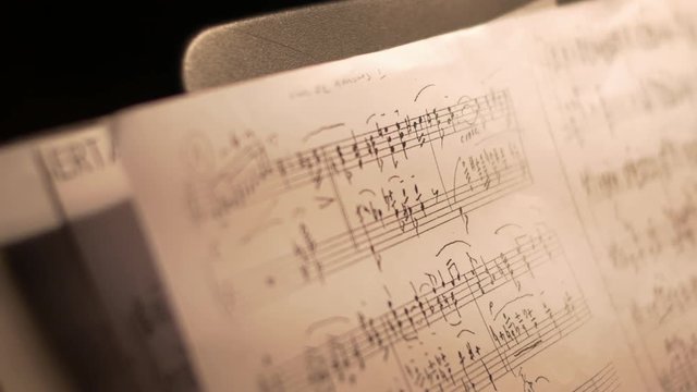 Handheld close-up of a music sheet showing notes of a tango piece.