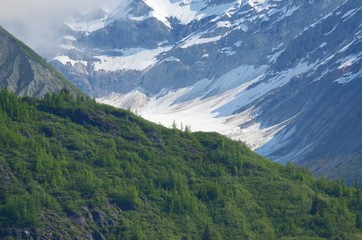Fototapeta na wymiar Close up on Mountain Glacier in Alaskan interior on the way to Denali. Mountains, snow, ice, trees, and valley.