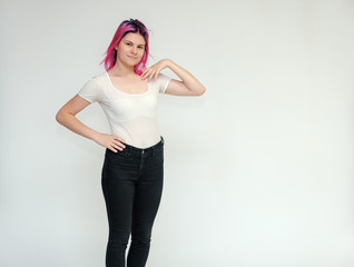 Portrait below the knee of a young beautiful girl teenager in a white T-shirt and black jeans with...