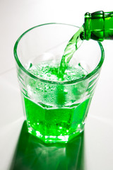 glass with green soda and bottle