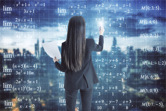 Businesswoman looking at formulas - Powered by Adobe