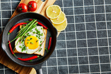 Scrambled eggs on the bread in the frying pan with vegetables - 277410441