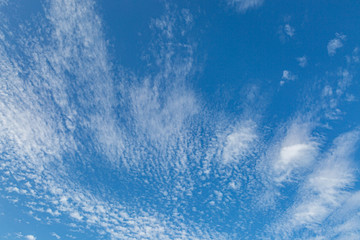 Looking up at a full frame photograph of blue sky and wispy white clouds